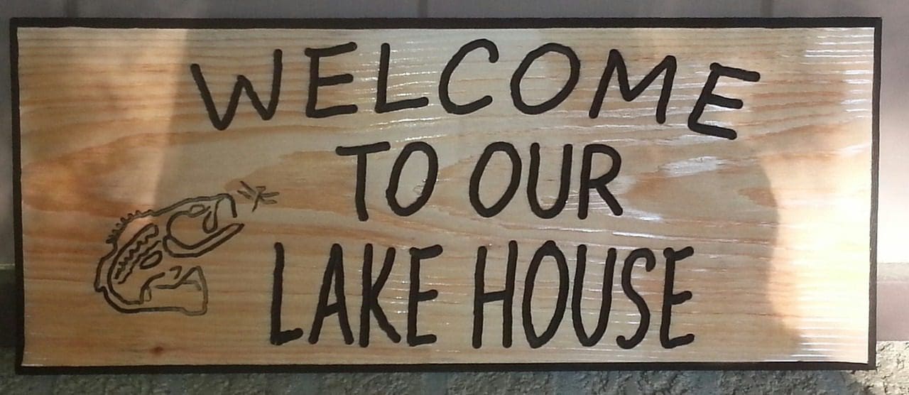 Wooden sign reading "Welcome to Our Lake House.